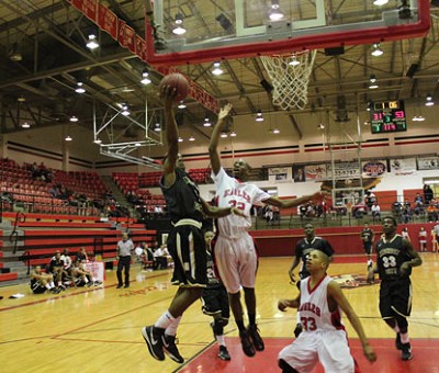 Mikey Smith puts in two of his nine points as Alize Travis contests.