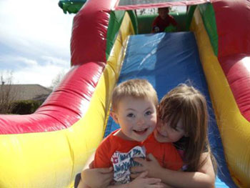 Mark�s daughter, Raegan Cook helps Cooper Lucas down an inflatable.